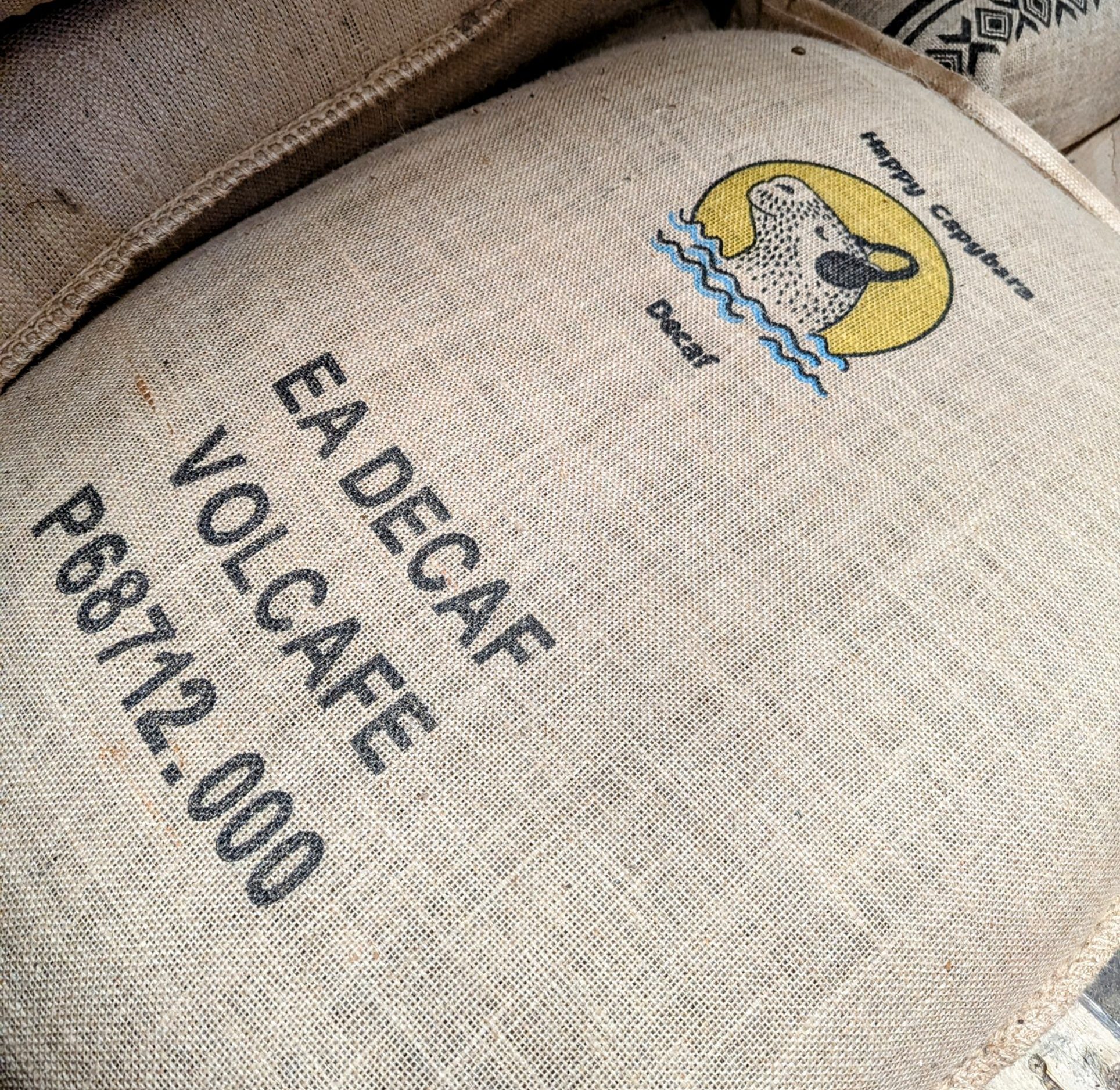 Picture shows 70kg of coffee is hessian sack in our warehouse with Happy Capybara logo stamp