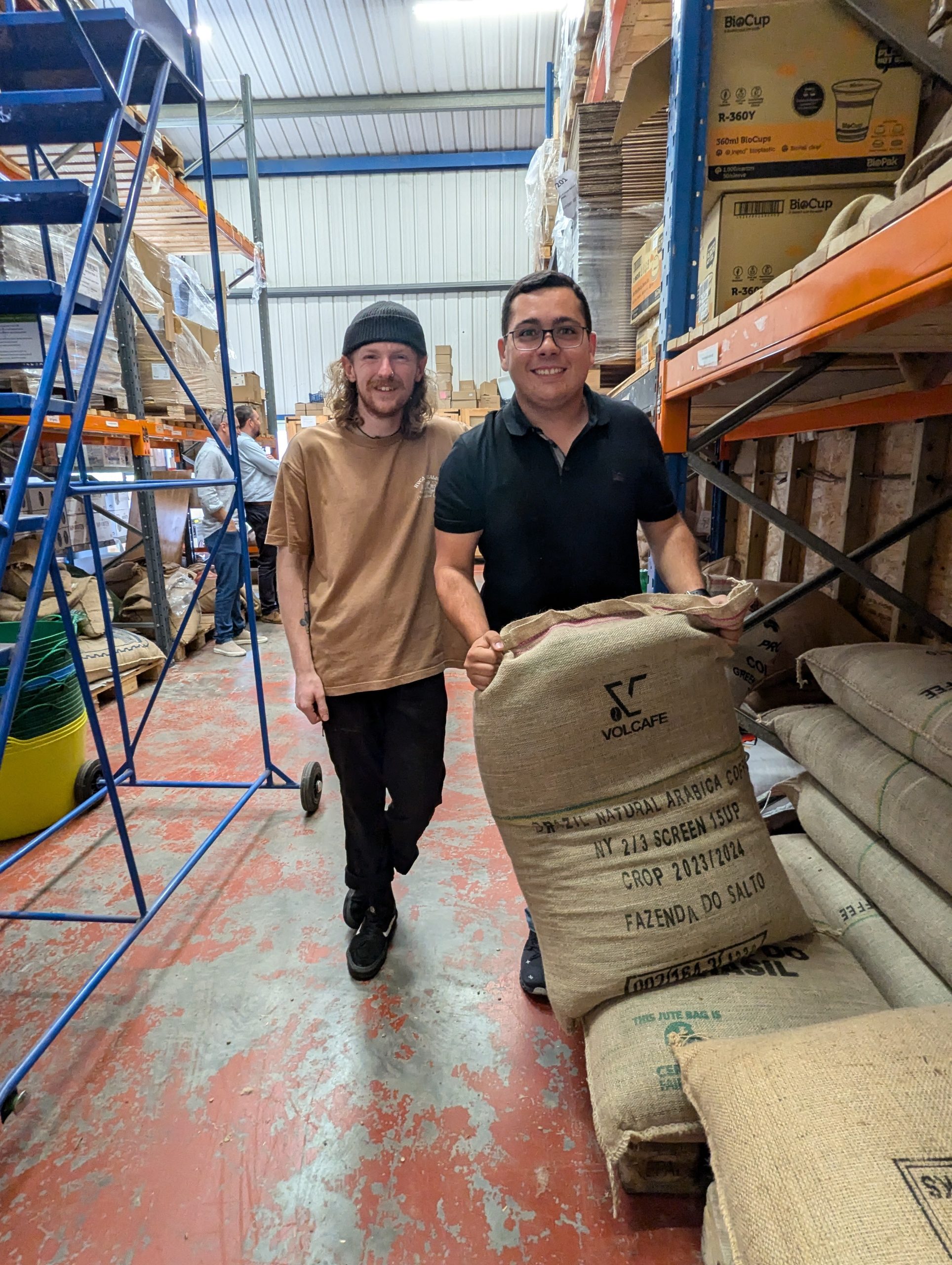 See Gabe and coffee producer Otavio Reis, from Fazenda do Salto in Brazil standing in our green bean warehouse at our roastery in Buckfasteligh.